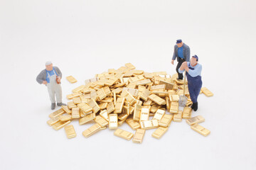 Miniature Workers Handling a Large Pile of Tiny Gold Bars