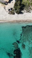 Vue verticale de la plage de Saint Cyprien en Corse, r&eacute;v&eacute;lant le sable blanc, l&rsquo;eau turquoise et les fonds marins sombres.