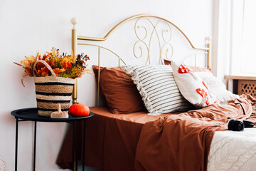 Cozy bedroom with autumn decor and warm tones in a bright space