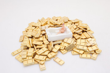 Miniature Figure Relaxing in Tub Surrounded by Gold Bars