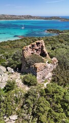 Ruines d&rsquo;une tour g&eacute;noise &agrave; base carr&eacute;e surplombant la baie de Saint Cyprien en Corse, entour&eacute;e de maquis et dominant la mer turquoise.