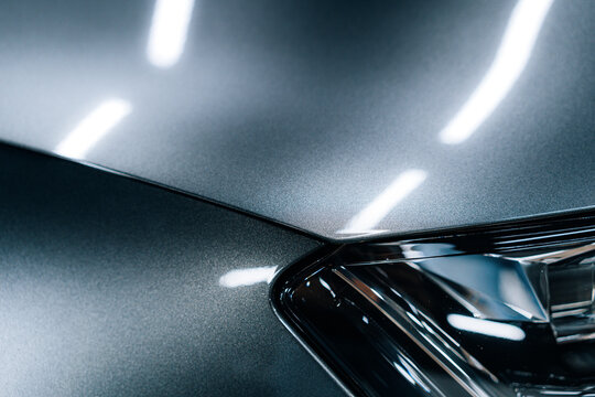 Close-up detail of PPF protective film edge on metallic car paint, showing precise installation and gloss reflections in studio lighting, focus on fuel cap area and surface protection layer