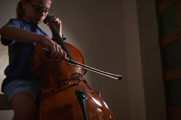 Young Musician Playing the Cello in a Dimly Lit Room