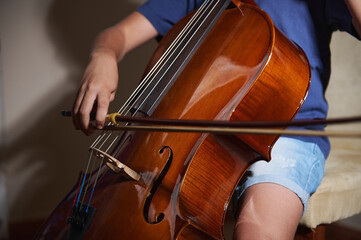 Close-Up of Person Playing the Cello in a Well-Lit Room