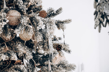 Decorative winter holiday tree adorned with sparkling ornaments and snow like foliage