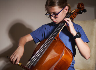 Young Girl Practicing the Cello with Focus and Passion in Natural Lighting