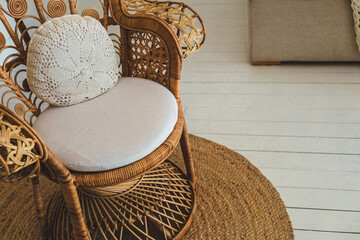 Woven chair placed on a round rug in a bright and cozy indoor space