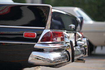 The chrome bumper of a vintage car glows with light, adding to the car classic allure and sleek...