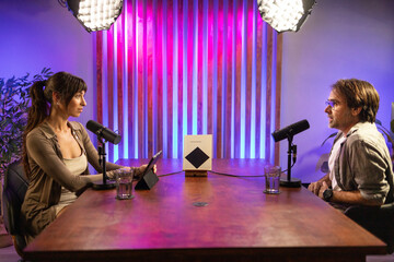 Podcast discussion between man and woman in studio