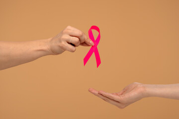 Hands Holding Pink Ribbon for Breast Cancer Awareness