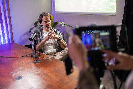 Man recording podcast in studio setting