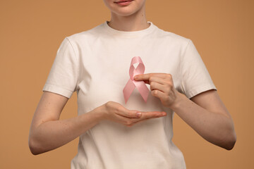 Woman Holding Pink Ribbon Symbolizing Breast Cancer Awareness