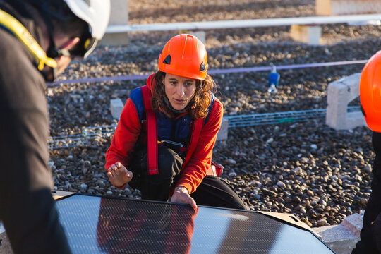 Rooftop solar panel installation by focused workers