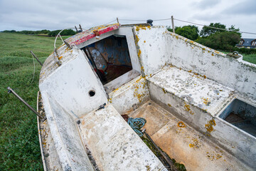 Abandoned vessel – a lonely boat marooned in a desolate tidal estuary. The image evokes themes of...