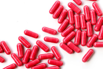 Red astaxanthin supplement capsules on a white background.