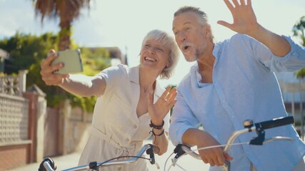 Retired couple sharing joyful moment while leaning on bicycles, laughing together during sunny day in peaceful suburban neighborhood, embodying love and active aging