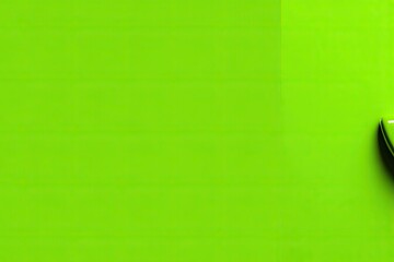 Obraz premium A vibrant lime green surface with a portion of a dark object