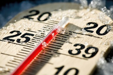Close-up of wooden thermometer showing freezing temperature.  Frost and ice cover the surface