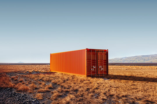 Bright orange industrial container stands alone in vast landscape