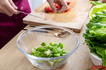 A young Chinese woman is making a vegetable salad