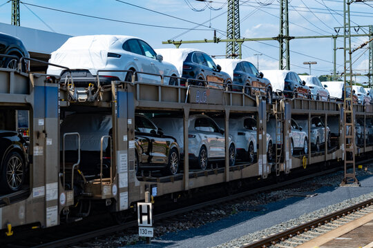 train carrying multiple new Porsche macan SUVs, some covered and some uncovered, awaiting destination, Bebra, Germany