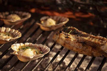 Delicious scallops and fish grilling on barbecue for summer meal