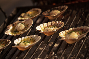 Chef grilling delicious scallops with garlic and parsley on barbecue