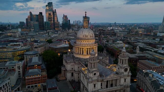 Panoramic aerial view of the illuminated city skyline of London, England, behind the St. Pauls Cathedral during dusk
