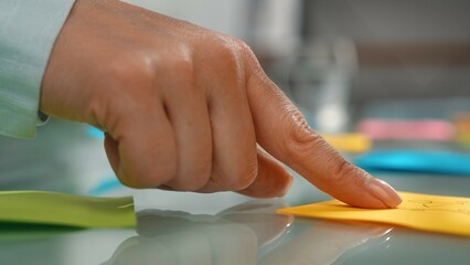 Hand Picking Colorful Sticky Note from Glass Surface