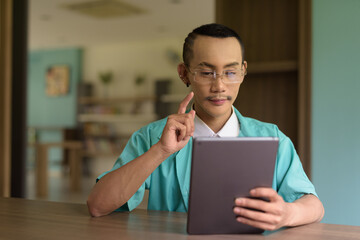 young gay man doctor with tablet computer talking