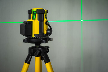 laser level machine equipment with the green laser lines shown on concreat wall at the front