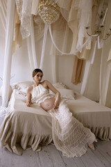 beautiful pregnant slavic woman with dark hair in elegant dress posing in elegant bedroom