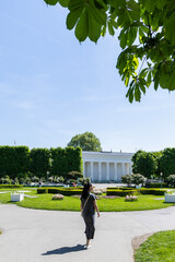 Female tourist looks at the Austrian Parliament building. View from the back. Austria, Vienna