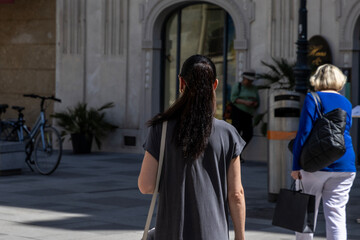 Female tourist walks in a historical city and sees the sights. View from behind. Austria, Vienna