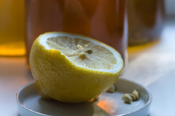 Lemon on a plate with a glass of lemonade in the background