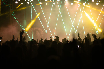 Crowd at concert and colorful stage lights.