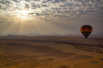 Hot air balloon drifting over the Namib desert at dawn, Namibia