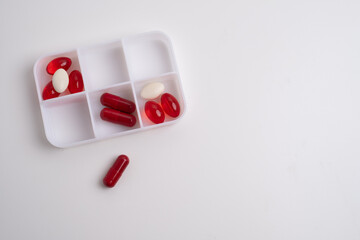 Pill box with various pills, vitamins and dietary supplements for every day. Space for text.