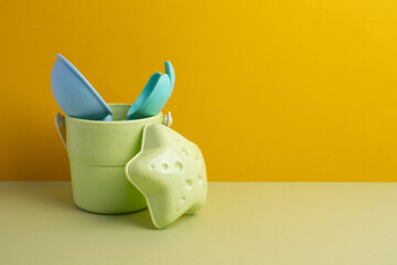 Children's toys, a shovel, a rake and crispy colorful snacks. Summer mood on the beach