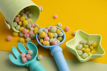Children's toys, a shovel, a rake and crispy colorful snacks. Summer mood on the beach