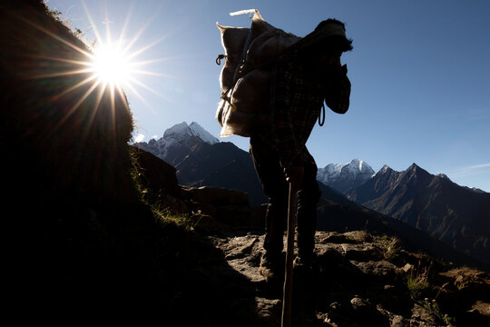 Unrecognizable porter carrying heavy load in Nepal