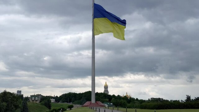 Ukraine flag waving over city. blue and yellow colors