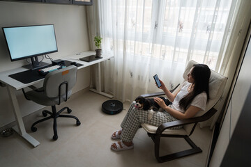 Woman in home office with dog and robot vacuum