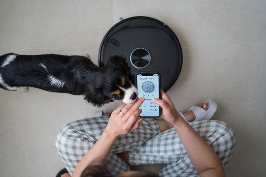 Woman managing robot vacuum with her phone