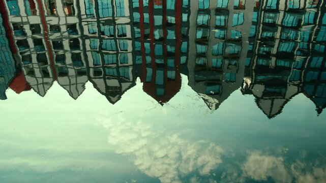 Colorful dutch houses reflecting upside down in canal water