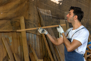 Carpenter man working with wood plank in carpentry workshop