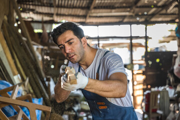 Carpenter man working with wood plank in carpentry workshop