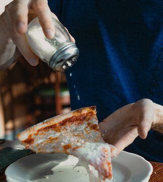 Man enjoying cheese pizza at Brooklyn restaurant