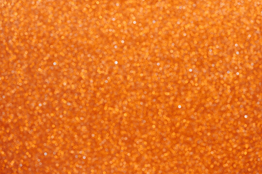 Colorful orange glitter bokeh background vibrant for holiday design textures