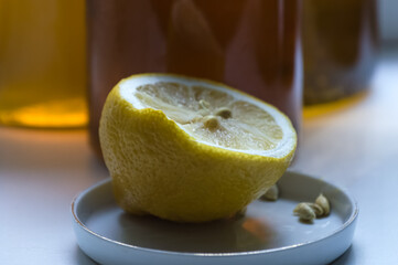 Still life with lemon and honey in a glass jar on a white background